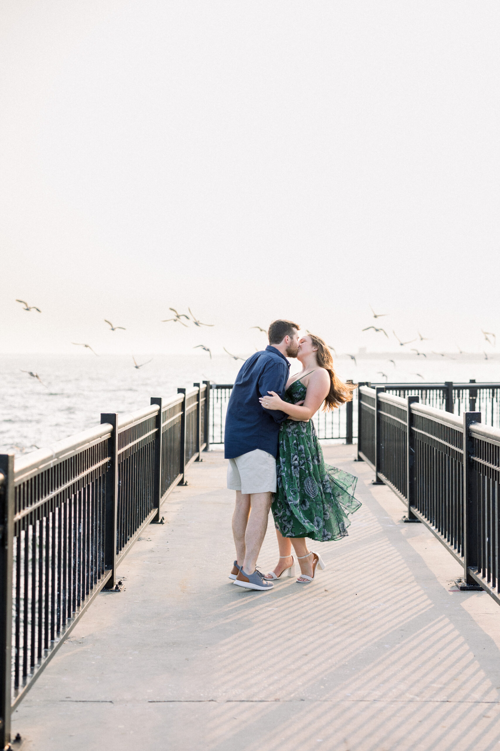 Couple Kissing on Pensacola Pier with Birds and Water Behind Them